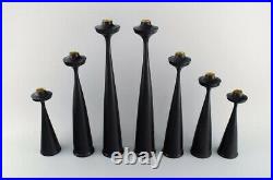 A collection of seven Scandinavian designer candlesticks in wood and brass